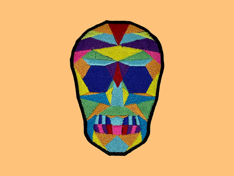 Flaca embroidered patch, the same geometric mask design as the Flaca jacket, iron-on backing